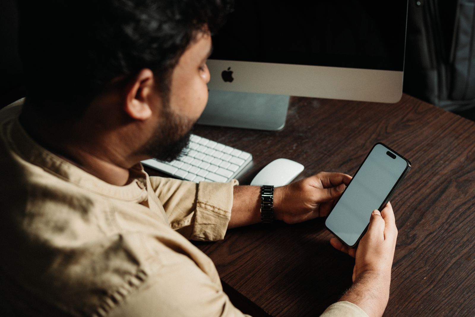 Trabalhador olhando a tela do celular ao receber uma convocação de trabalho intermitente